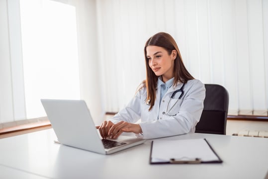 3448_Doctor typing report on laptop.-1