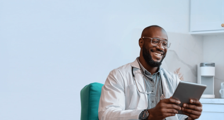 doctor holding ipad in office smiling