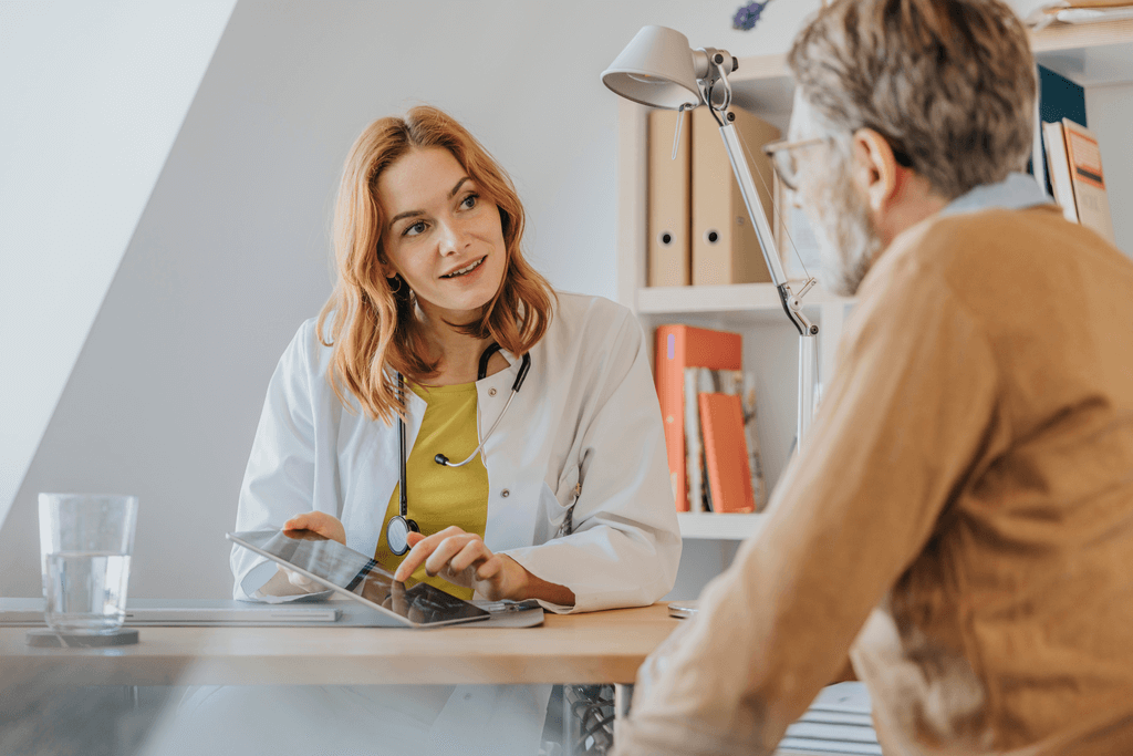 Doctor with digital tablet talking to patient