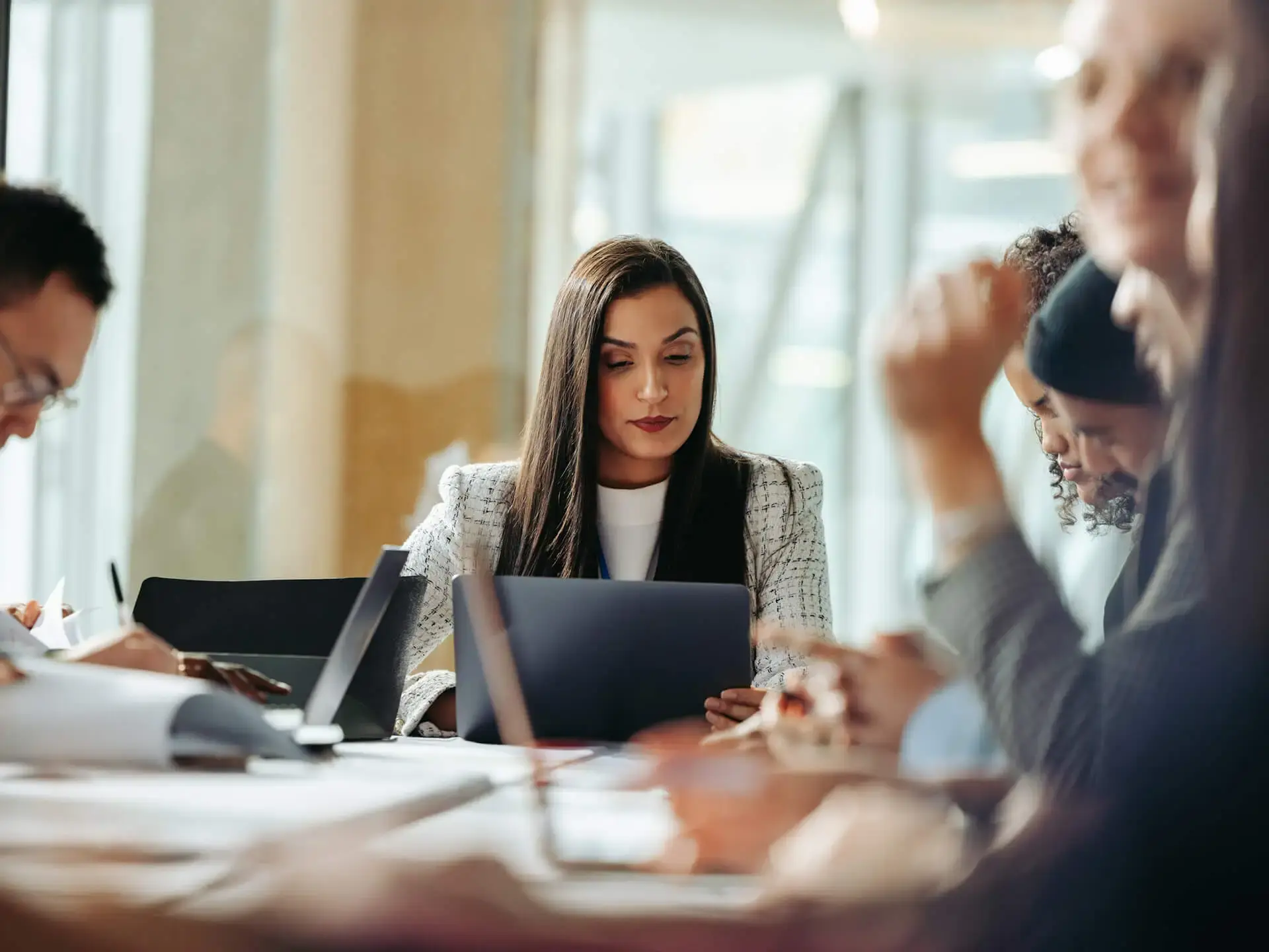 Woman sitting in business meeting looking at laptop screen