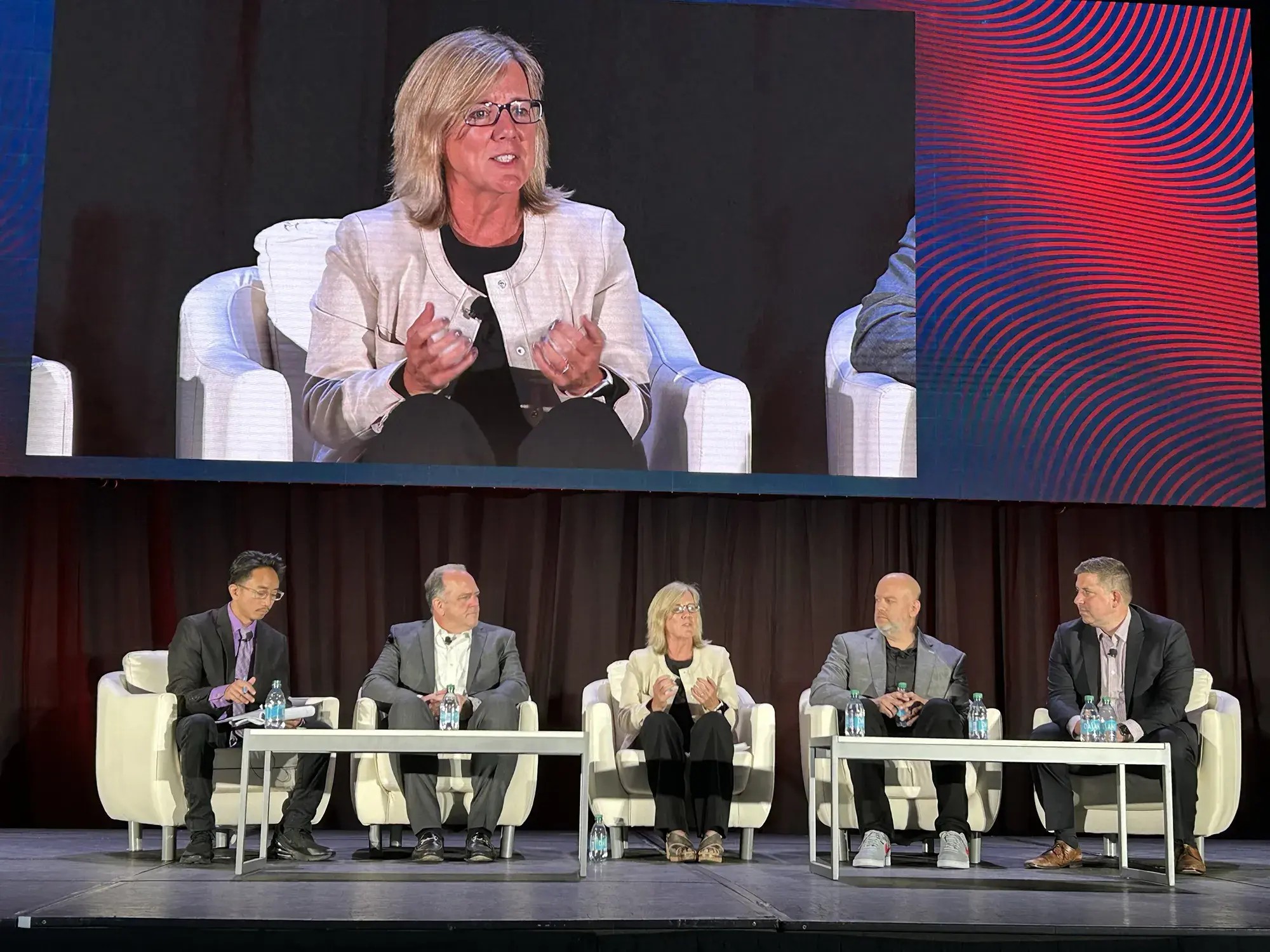 Keynote panel split screen with panelists and woman speaker